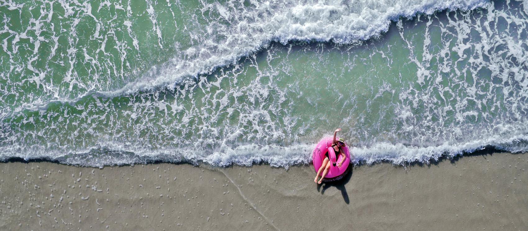 躺在火烈鸟漂筏上漂浮冲浪,在佛罗里达海滩上度过完美的一天 躺在火烈鸟漂筏上漂浮冲浪,在佛罗里达海滩上度过完美的一天